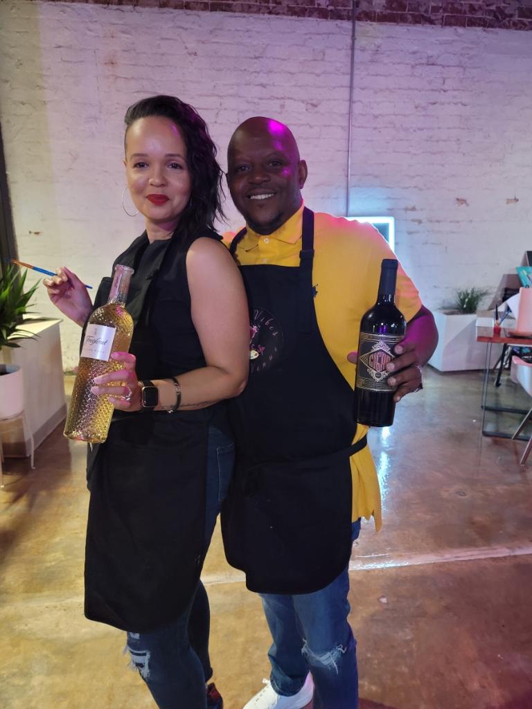 Two people posing for a picture with wine.