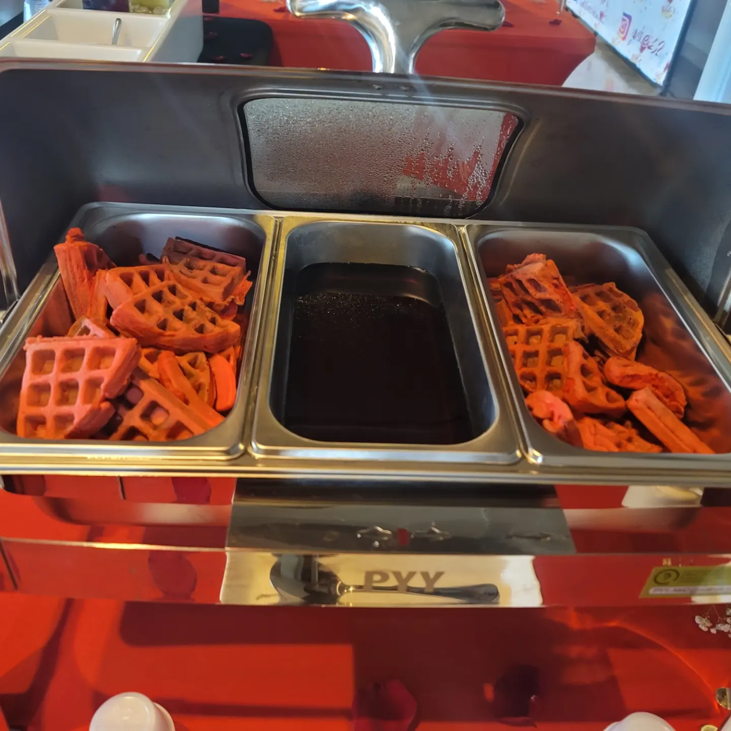 A large metal tray filled with orange colored food.