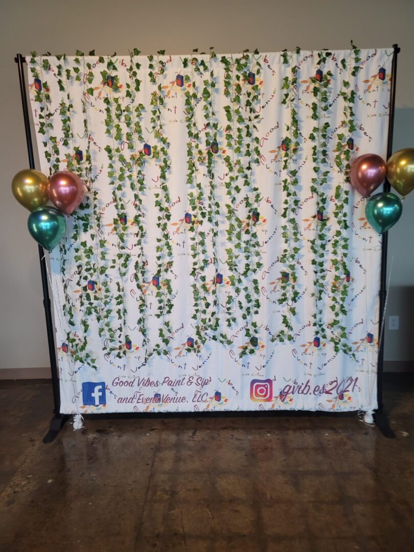 A photo booth with balloons and flowers on it.
