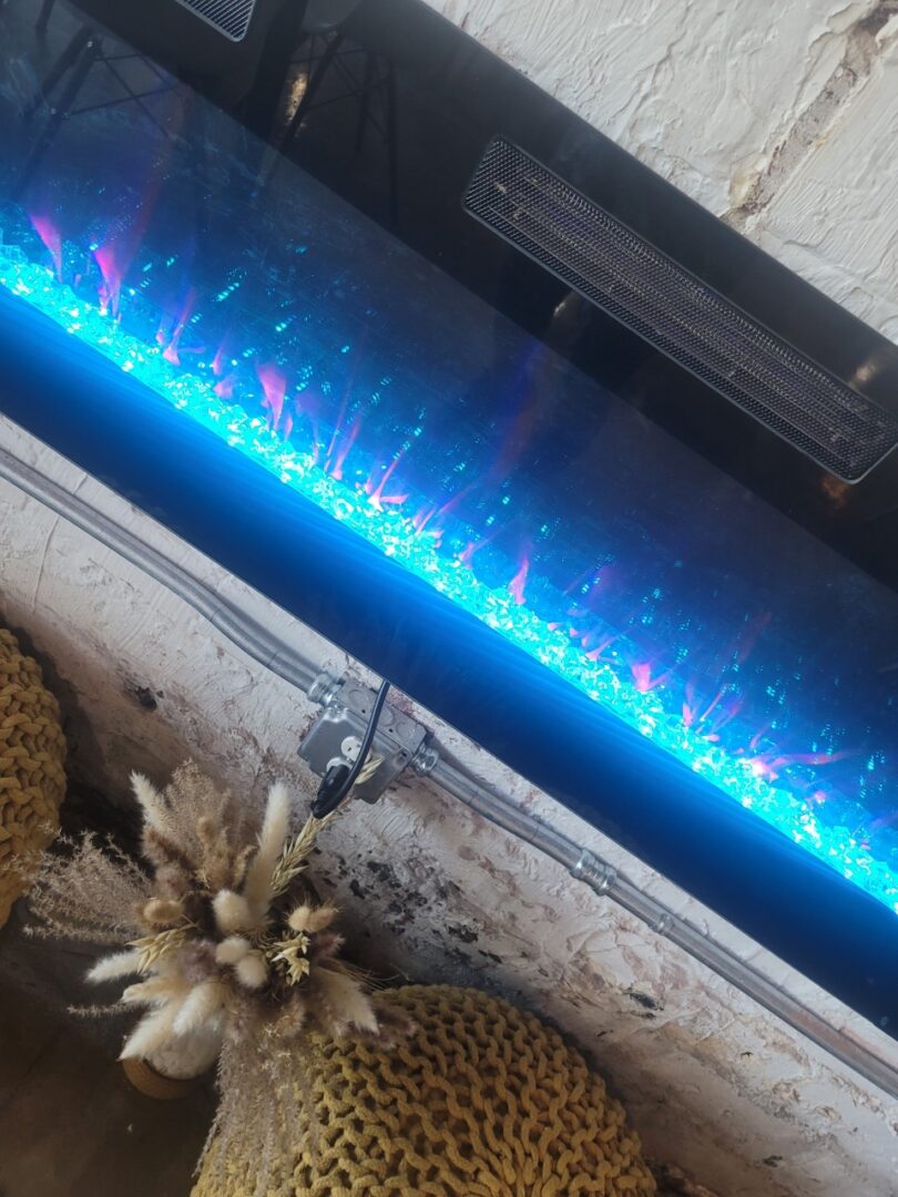 A fireplace with blue lights and pineapples in the background.